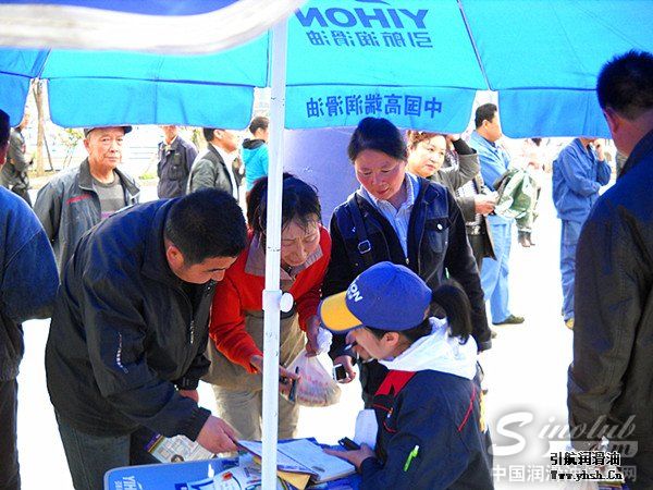 舞台车前的凉亭下,工作人员在接受行人关于引航油品特点的咨询